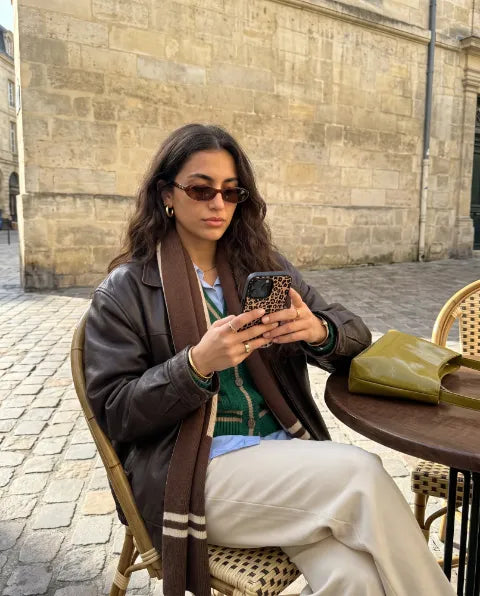 Hülle im Leo-Muster in der Hand, an einem Café-Tisch in der Altstadt